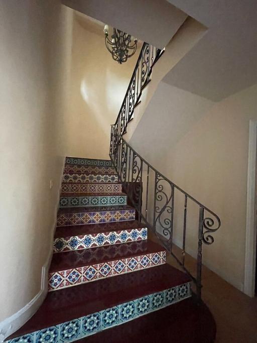 Decorative tiled staircase with elegant wrought iron railing in a home