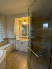 Spacious bathroom with glass shower and large mirror