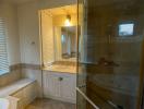 Spacious bathroom with glass shower and large mirror