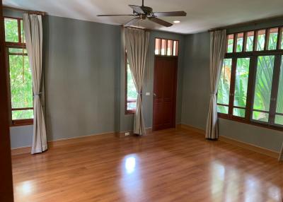 Spacious bedroom with hardwood floors and large windows