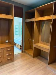 Spacious bedroom with empty wooden wardrobes and a view to the bathroom