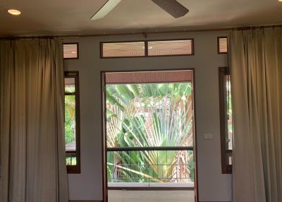 Spacious living room with large window and tropical garden view