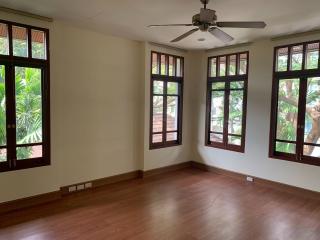 Spacious bedroom with large windows and hardwood floors