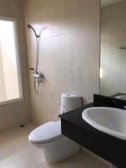 Modern bathroom with large mirror and beige tiles