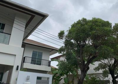 Exterior view of a modern two-story residential house with cloudy sky