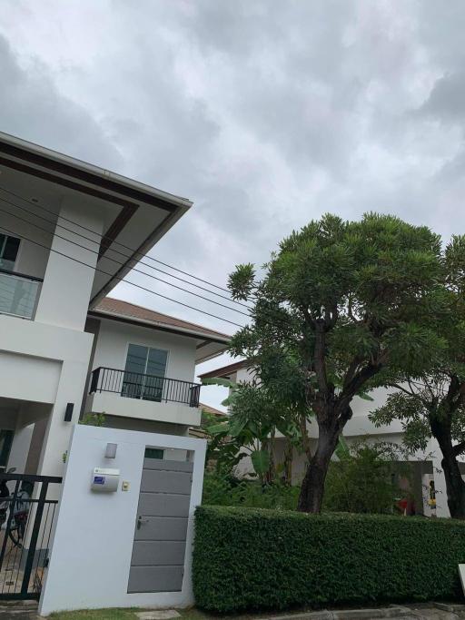 Exterior view of a modern two-story residential house with cloudy sky