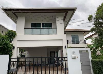 Modern two-story house with a prominent balcony and flat roof design