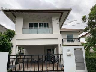 Modern two-story house with a prominent balcony and flat roof design