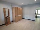 Spacious unfurnished bedroom with wooden wardrobe and ample natural light