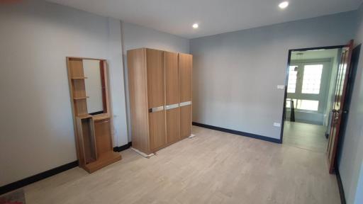 Spacious unfurnished bedroom with wooden wardrobe and ample natural light