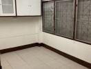 Spacious empty kitchen with white cabinetry and tiled flooring