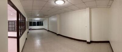 Spacious empty corridor inside a building with white walls and tiled floor