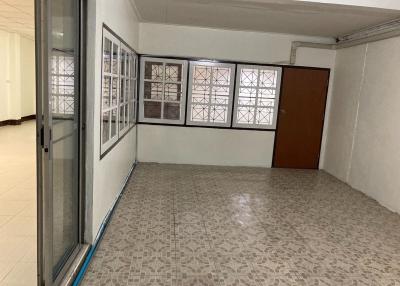 Spacious empty living room with patterned tiled flooring and multiple windows