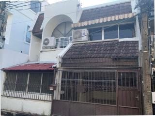 Exterior front view of a two-story residential building with a metal gate