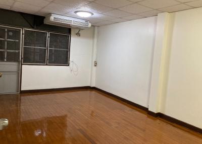 Spacious empty room with wooden flooring and air conditioning