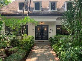 Front view of a charming house with lush garden