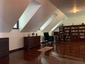 Spacious living room with slanted ceilings and hardwood floors