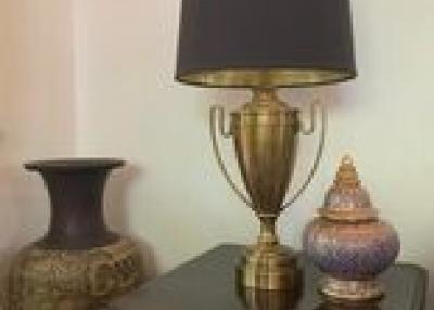 Elegant bedroom decor with a stylish lamp and ornamental vases on a dresser