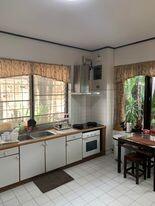 Spacious kitchen with natural lighting, equipped with appliances and a dining area