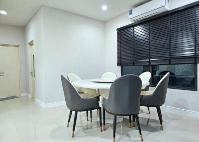 Modern dining room with large table, chairs, and air conditioning