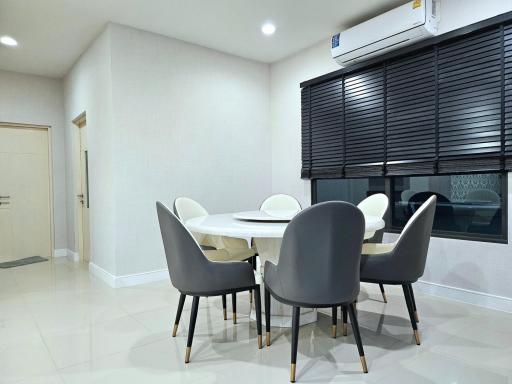 Modern dining room with large table, chairs, and air conditioning