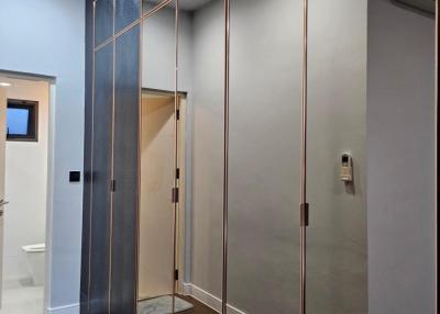 Modern hallway with mirrored closet doors and hardwood floors