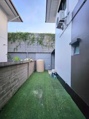 Compact modern outdoor space with artificial grass and privacy fencing
