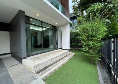 Modern home exterior with sliding glass doors and artificial grass