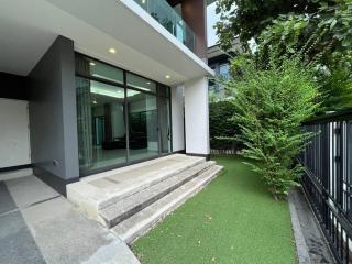 Modern home exterior with sliding glass doors and artificial grass