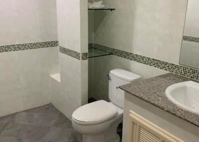 Compact bathroom with white toilet and modern sink