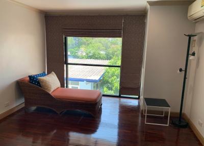 Cozy bedroom with large window and hardwood floors