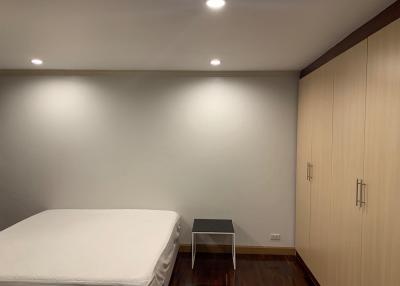 Minimalist bedroom with a double bed and wooden wardrobe