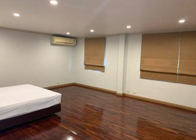Spacious bedroom with hardwood flooring and air conditioning