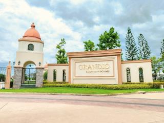 Elegant entrance sign of the Grandio Residential Area with landscaped surroundings under a blue sky