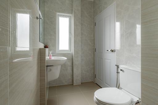 Modern bathroom with beige tiles and natural light