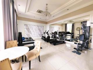 Spacious home gym with various exercise equipment and bright natural lighting