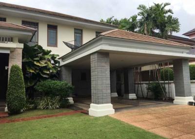 Elegant two-story residential house with landscaped front yard and columned entrance