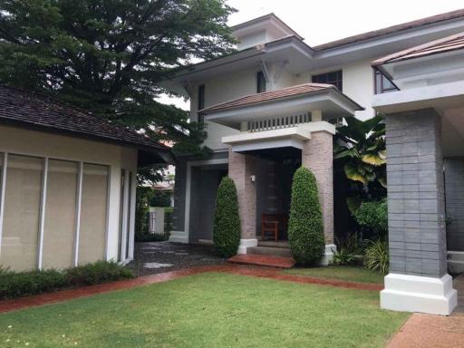 Exterior view of a two-story house with a lush front yard