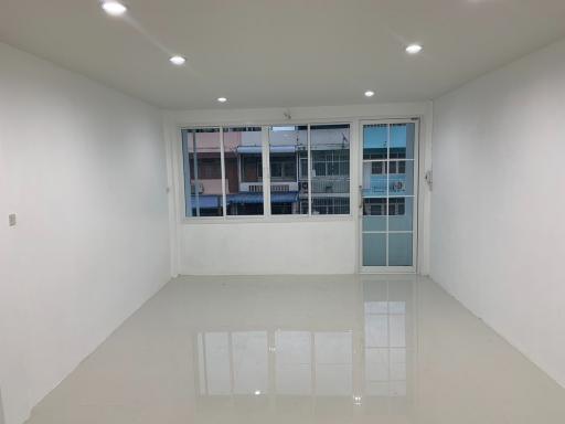 Spacious and well-lit empty room with large windows and tiled flooring