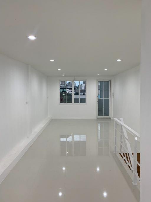 Spacious and well-lit empty room with glossy tiled flooring and multiple windows