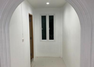 Brightly Lit Hallway Leading to Rooms with White Walls