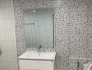 Modern bathroom with terrazzo tiling, floating vanity, and glass shower door