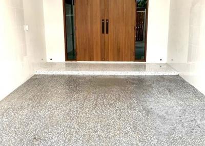 Elegant wooden front door with terrazzo flooring at the entrance