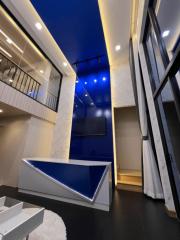 Modern living room with blue LED lighting and a mezzanine