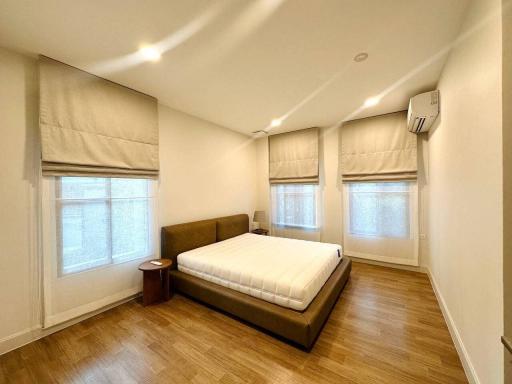 Modern bedroom with ample natural light and wooden flooring