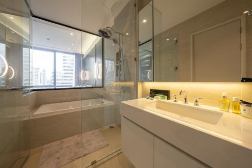 Modern bathroom interior with glass shower, bathtub, and city view