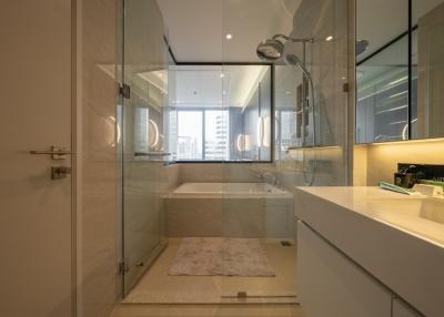 Modern bathroom with glass shower enclosure and city view