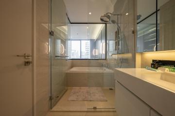 Modern bathroom with glass shower enclosure and city view