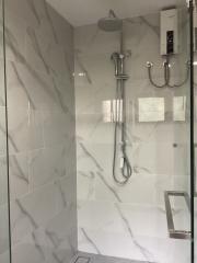 Elegant modern bathroom with marble tiles and glass shower enclosure