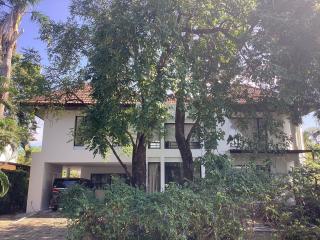 Two-story residential home with garage and surrounded by trees